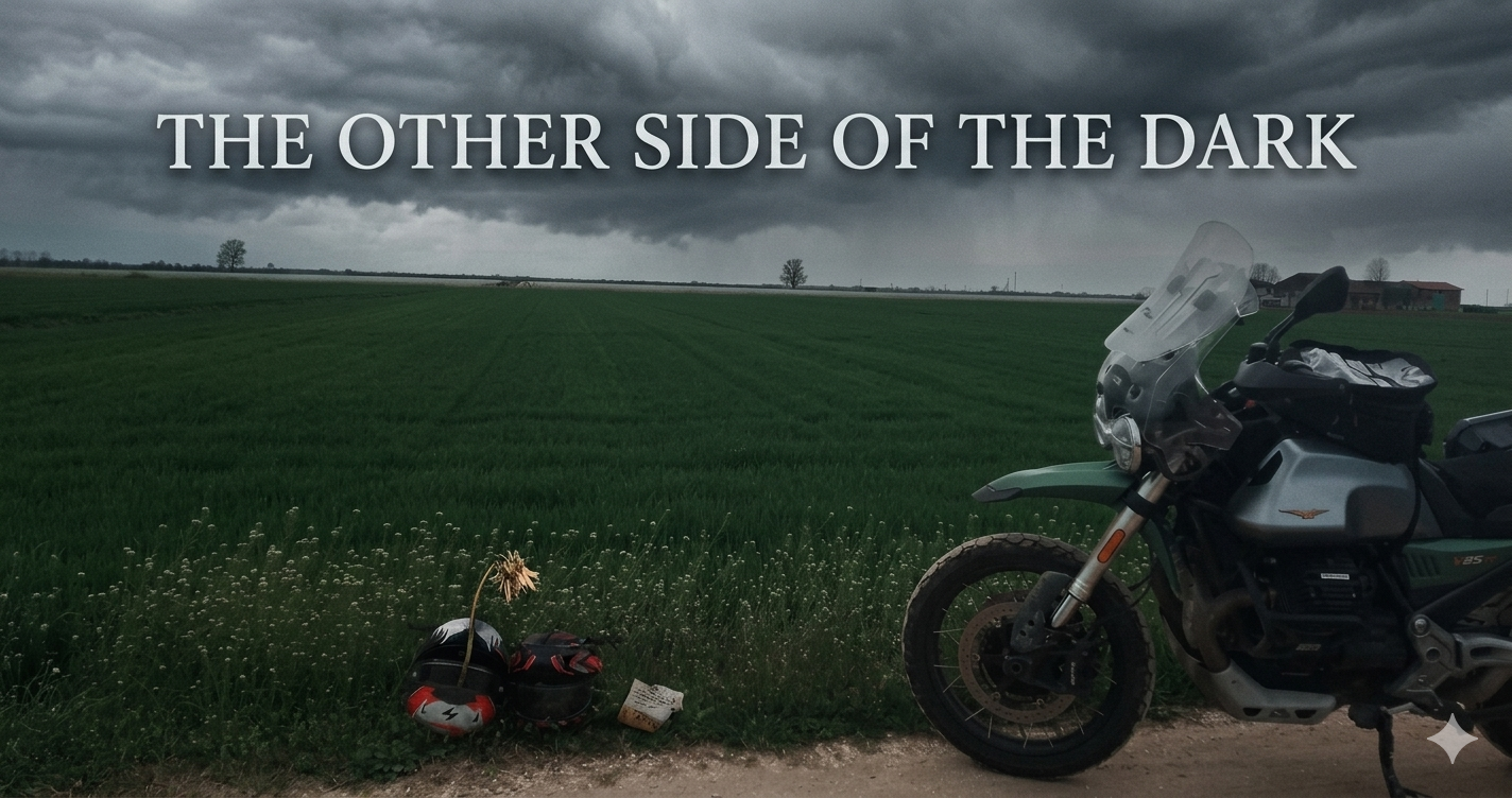 Moto Guzzi V85 TT e caschi in un paesaggio tempestoso con il testo "THE OTHER SIDE OF THE DARK".